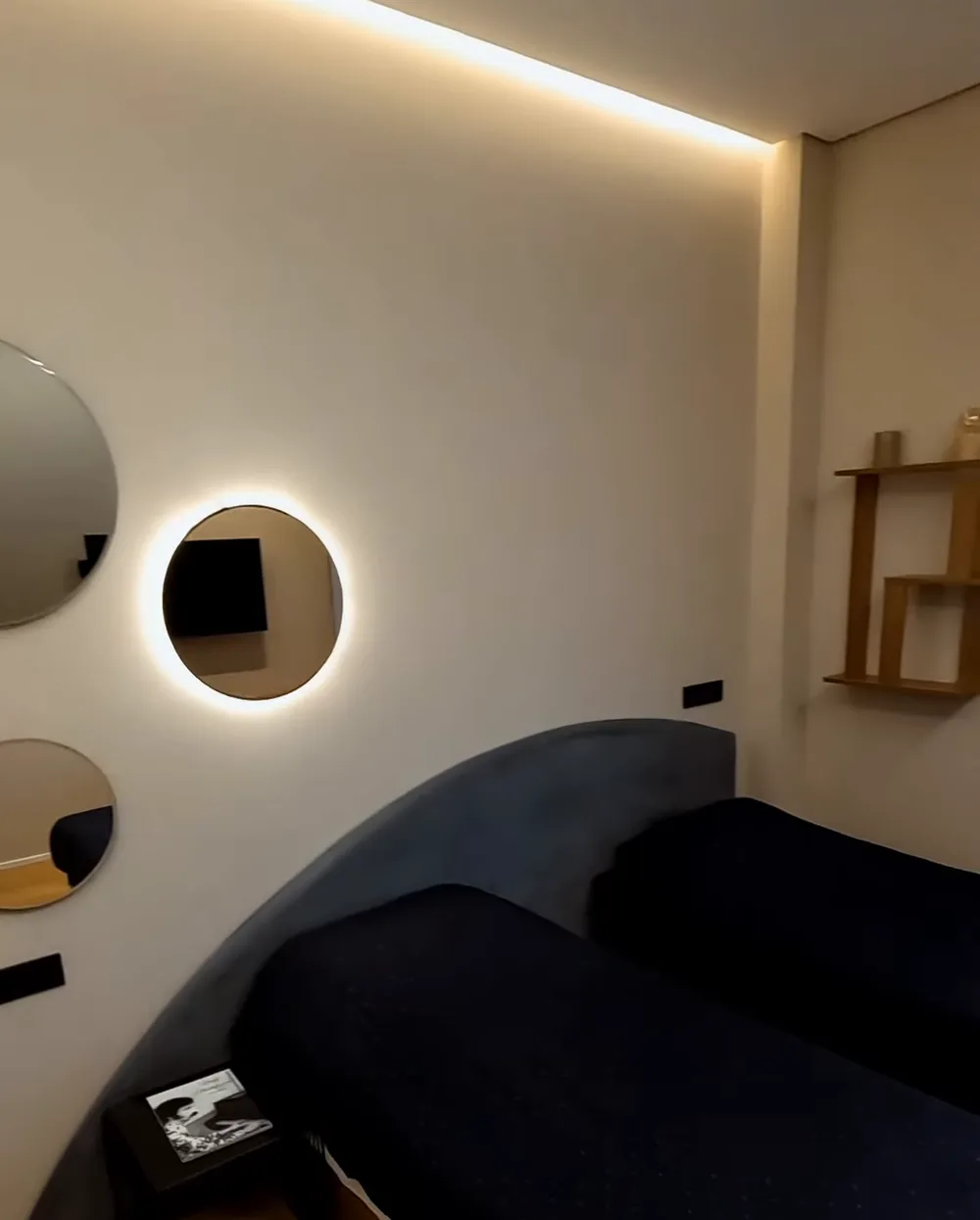 A children's or guest bedroom: two beds, round mirrors with lighting