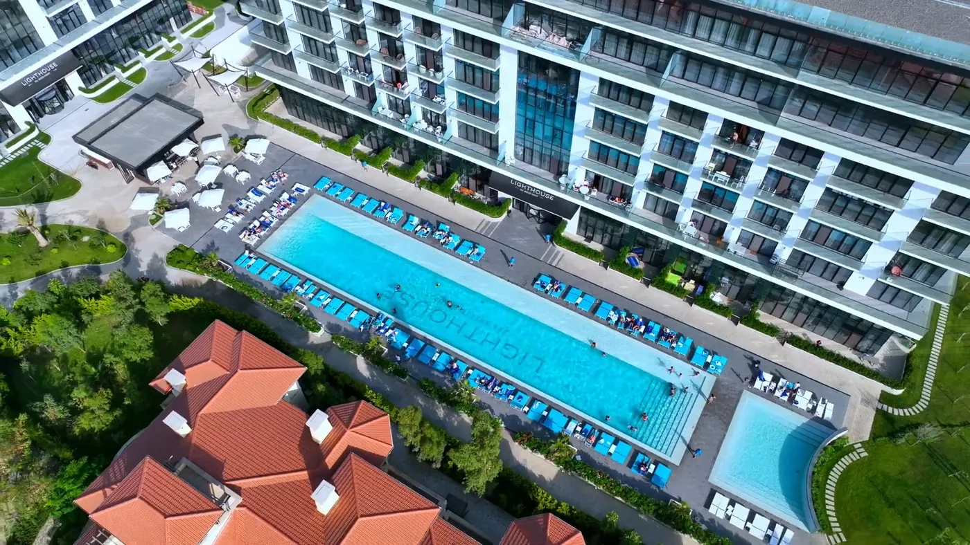 The pool in the Lighthouse courtyard with sun loungers and umbrellas, filmed by drone