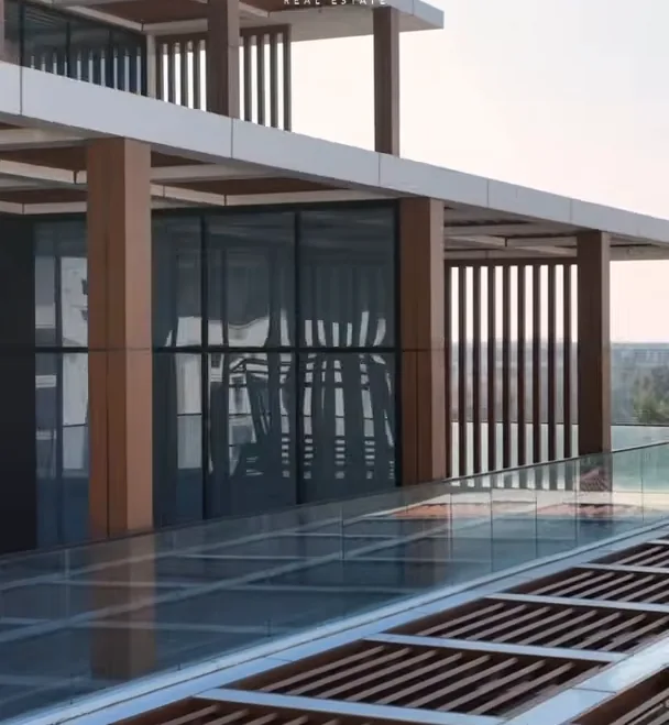 A top-floor terrace of Lighthouse: wooden slats and a glass railing